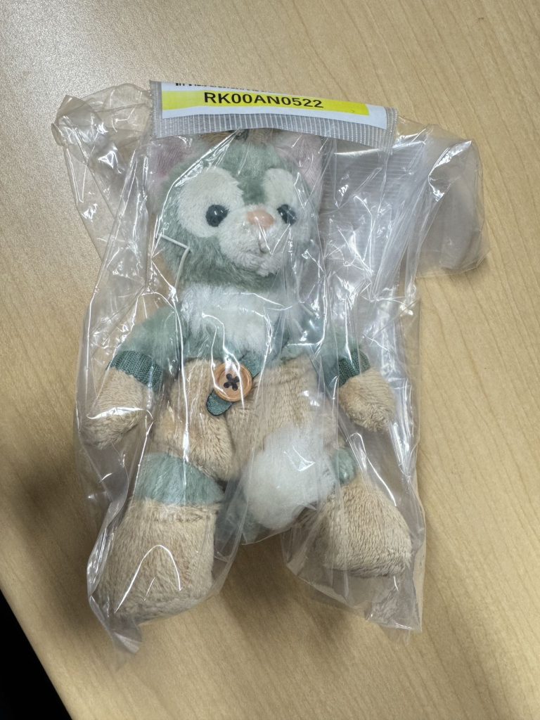 日本代购迪士尼杰拉托尼玩偶实拍,绿色服装与木质纽扣造型。