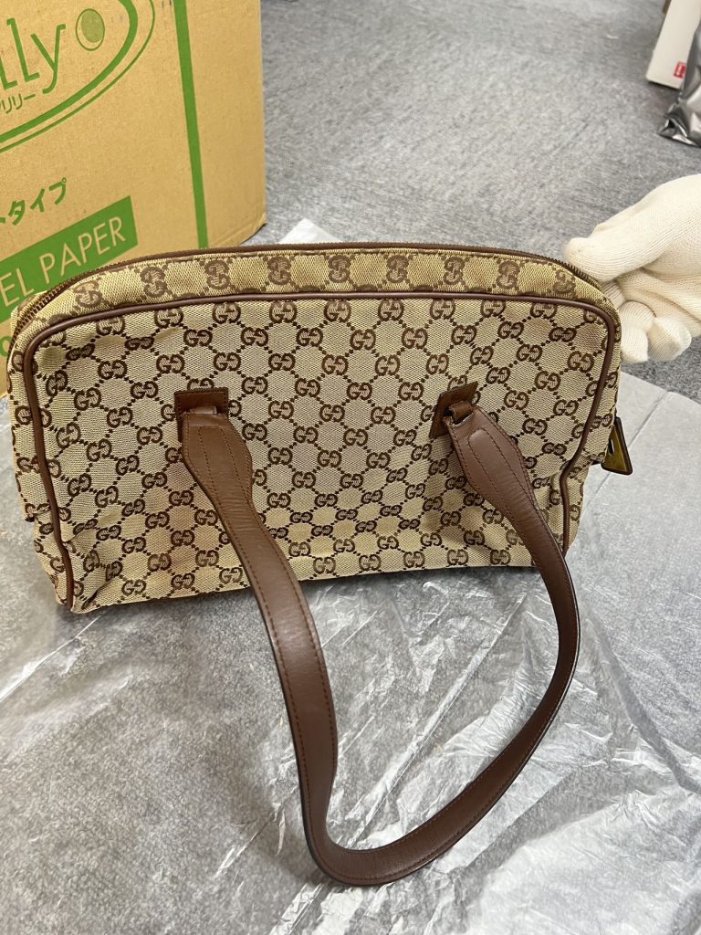 日本代购Gucci老花托特包开箱实拍图,展示包身帆布纹理与皮革手柄细节