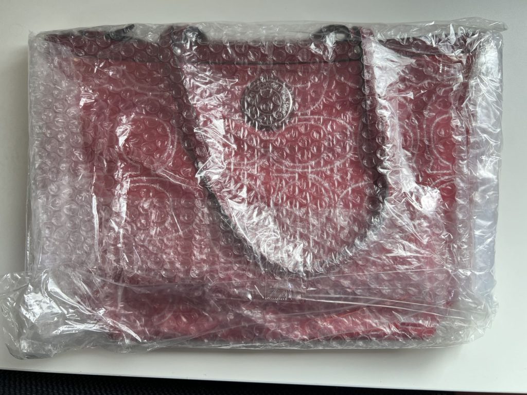 日本代拍红色真皮手提包开箱实拍,展示气泡膜防护与皮质光泽细节