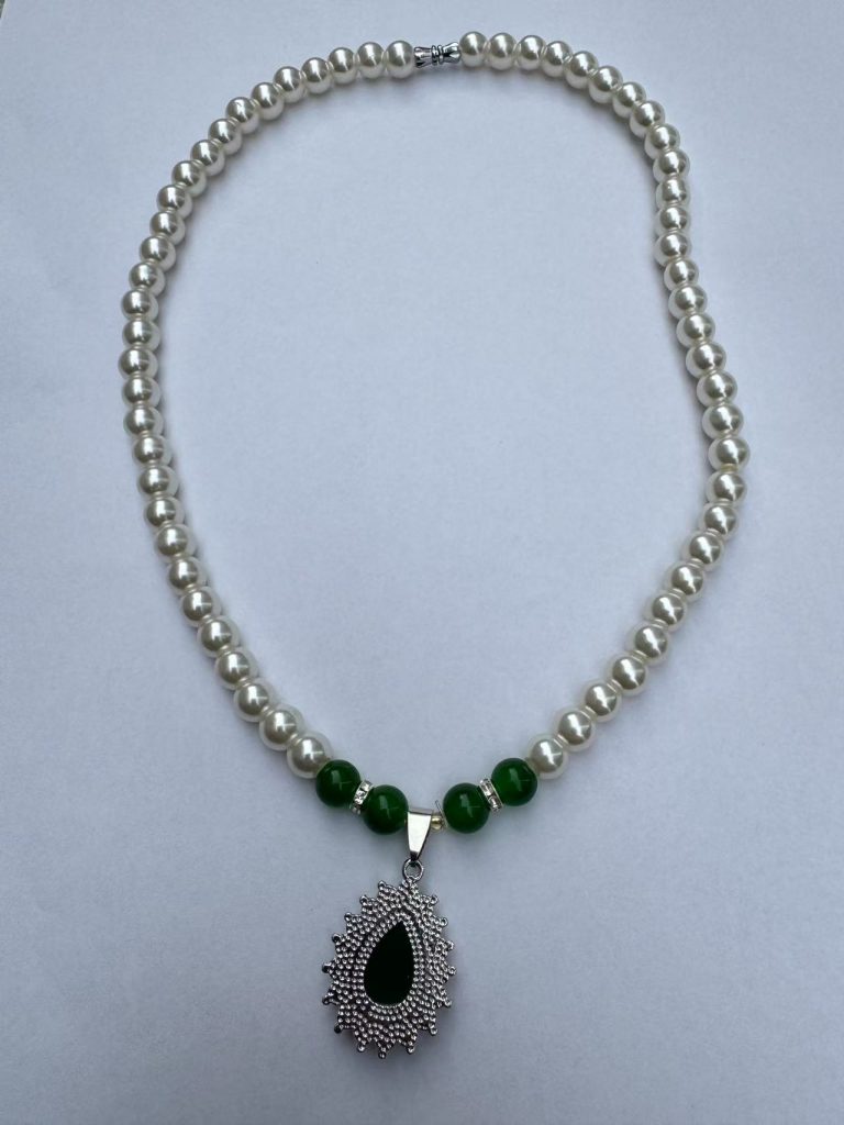珍珠搭配绿色玉石吊坠的项链开箱实拍,珠子圆润光泽自然。