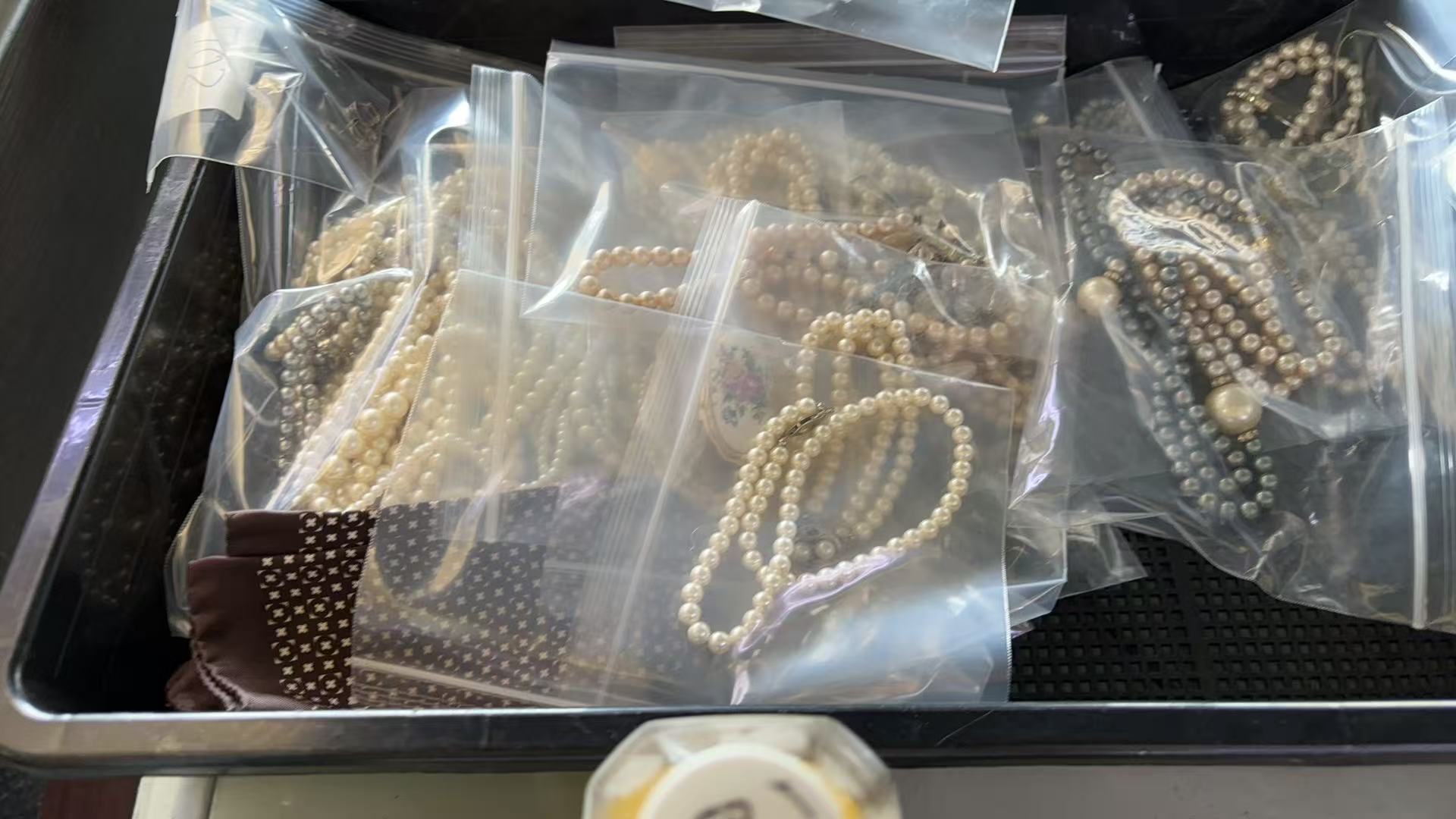 日本代拍珍珠项链批量货源展示,多条袋装珍珠手链和项链混装摆放